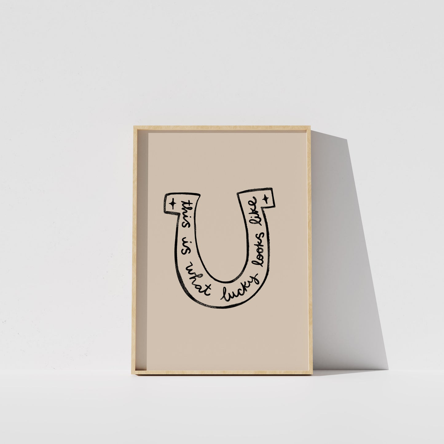 A framed poster with a simple black and white illustration of a horseshoe.