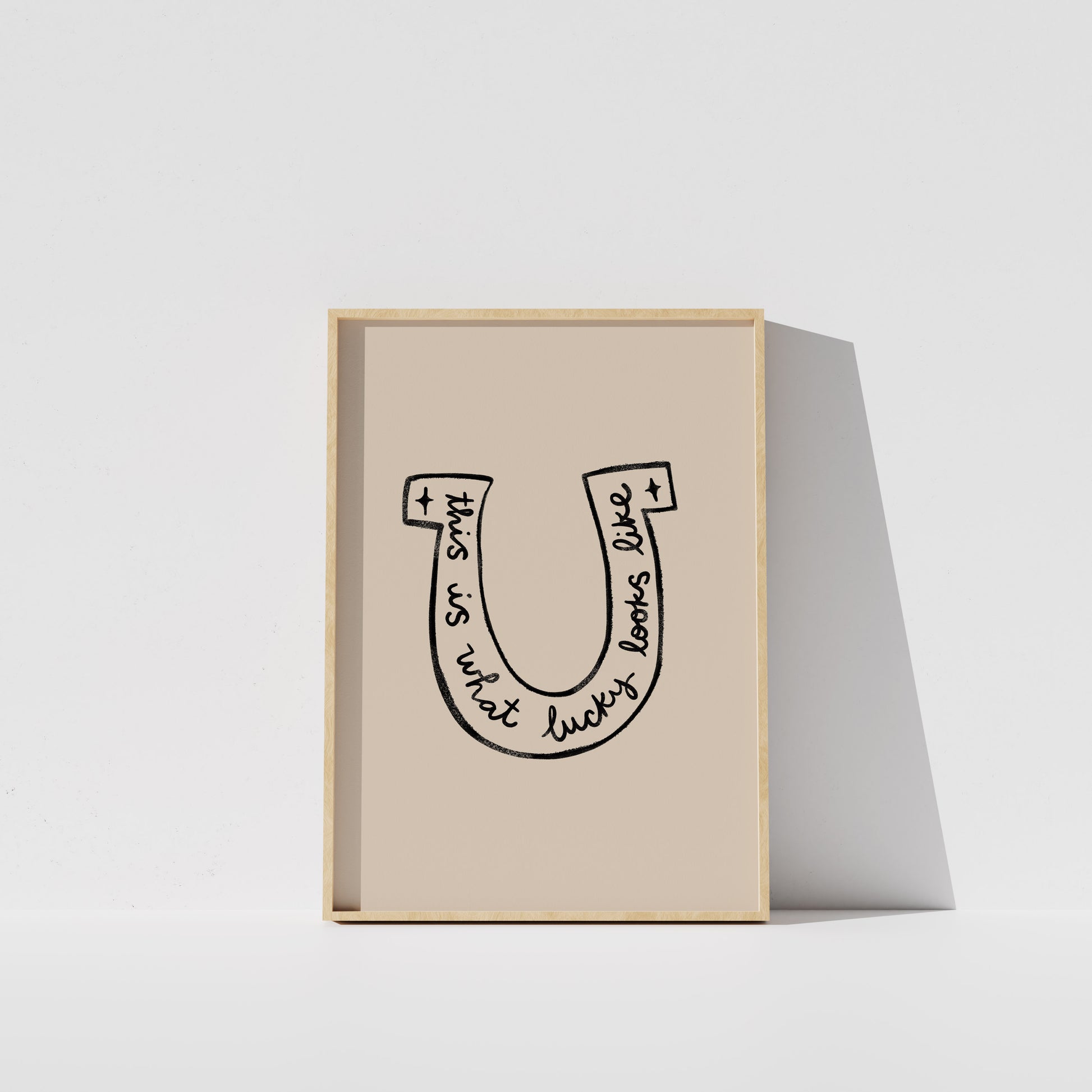 A framed poster with a simple black and white illustration of a horseshoe.