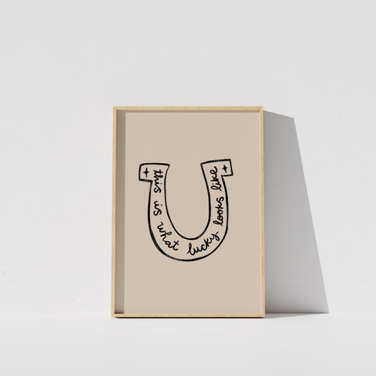 A framed poster with a simple black and white illustration of a horseshoe.