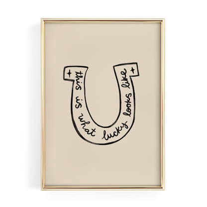 a framed artwork with a stylized letter 'U' containing the text "This is what lucky looks like".