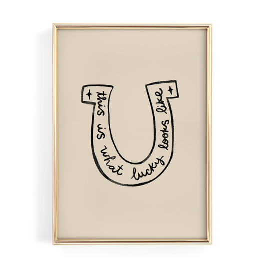 a framed artwork with a stylized letter 'U' containing the text "This is what lucky looks like".