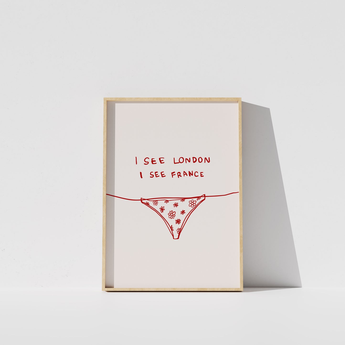 A framed poster with the text "I see London I see France" written on it, along with a simple illustration of a underwear or underwear-like object.
