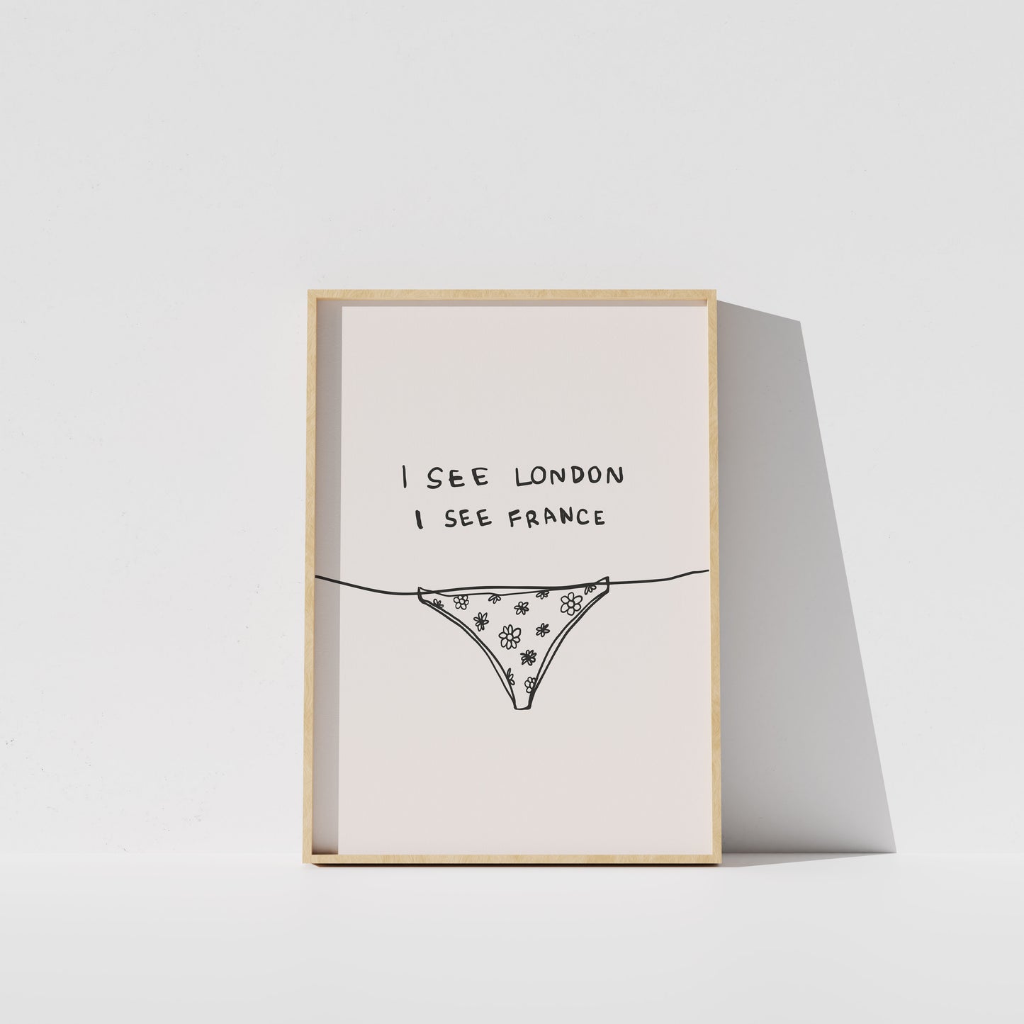 A framed print with the text "I see London I see France" and an illustration of a bikini bottom.
