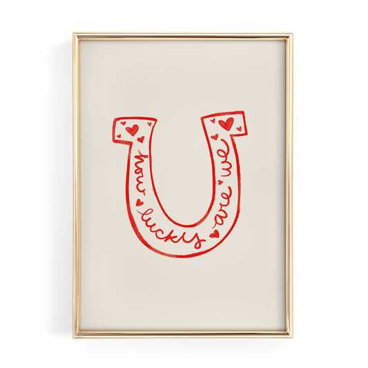 a framed poster with a large red letter "U" and the words "lucky we are" written in cursive script.