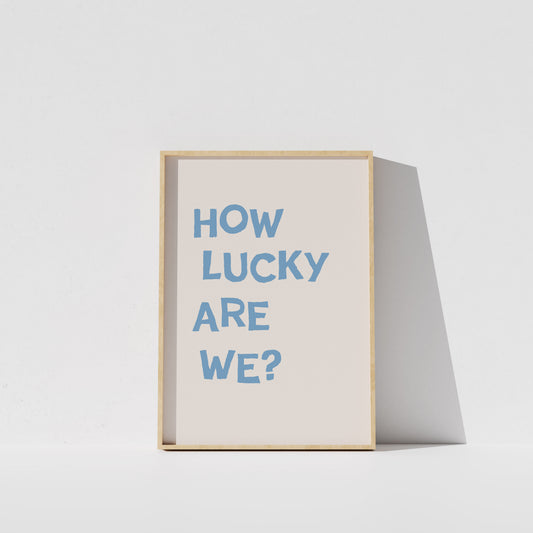 A framed poster with the text "HOW LUCKY ARE WE?" displayed on it.