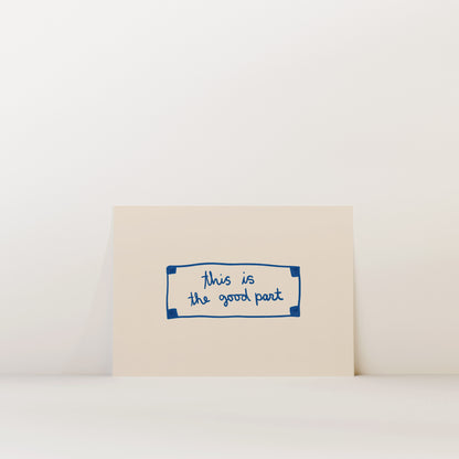 A beige card with a blue border and handwritten text that reads "This is the good part".