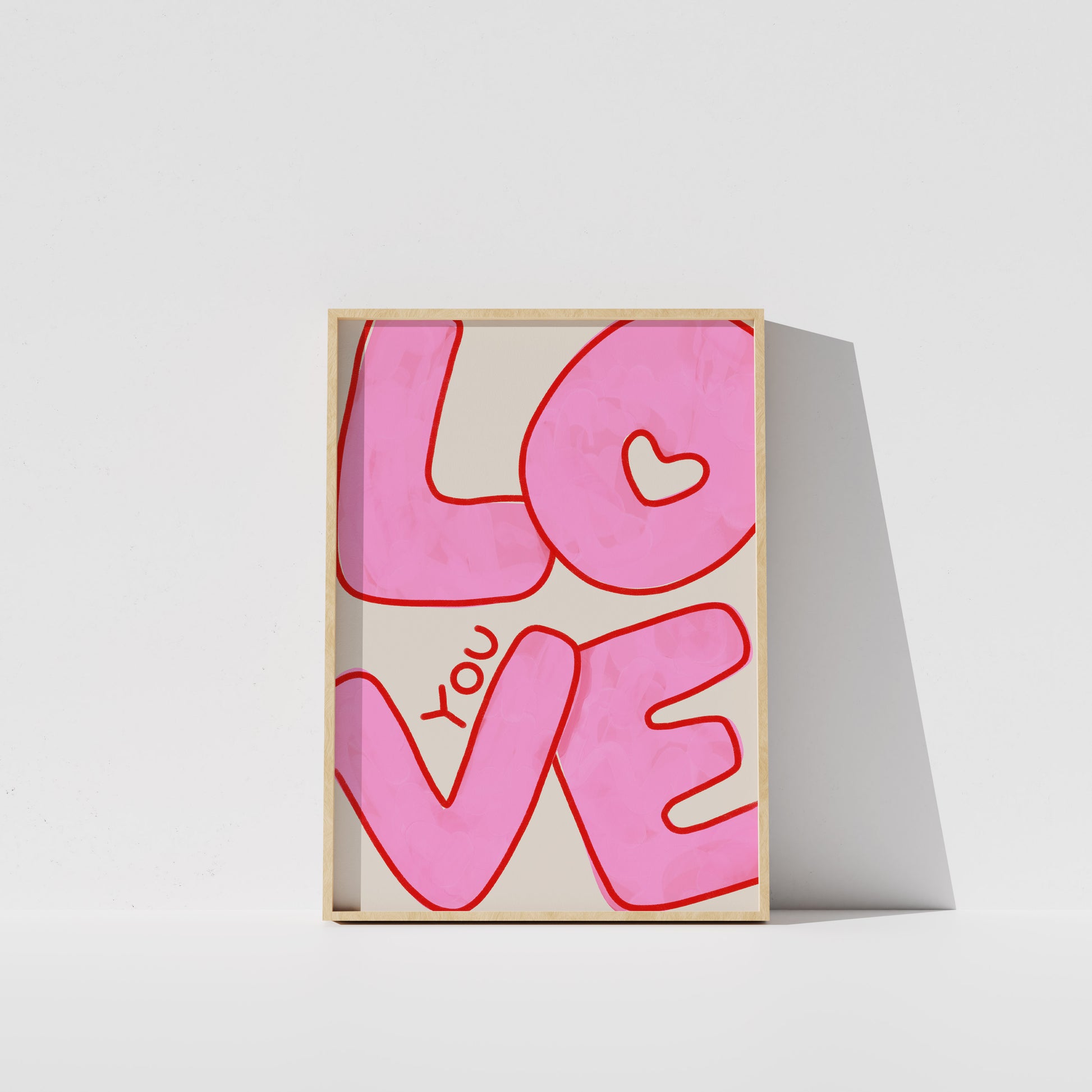 A framed poster with the word "LOVE" written in large pink letters.