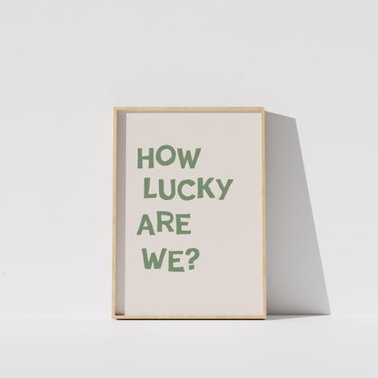 A framed poster with the text "HOW LUCKY ARE WE?" displayed on it.