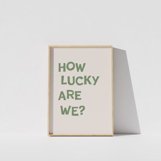 A framed poster with the text "HOW LUCKY ARE WE?" displayed on it.