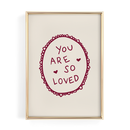 a framed piece of art with a heart-shaped design and the text "YOU ARE SO LOVED" written inside it.
