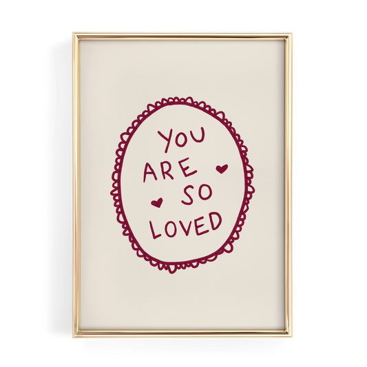 a framed piece of art with a heart-shaped design and the text "YOU ARE SO LOVED" written inside it.