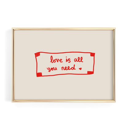 a framed piece of art with the text "love is all you need" written in red cursive on a beige background.