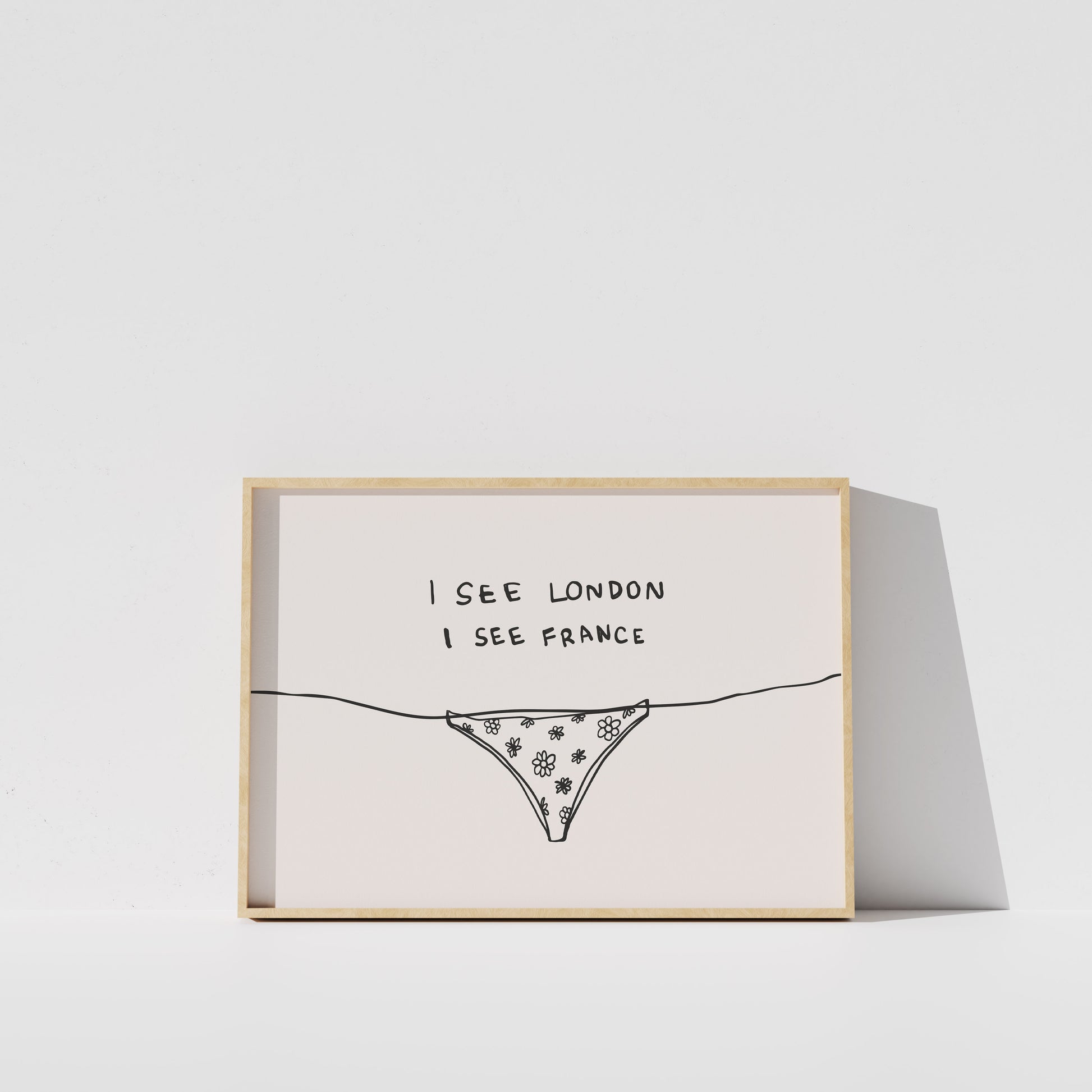 A framed print with a simple line drawing of a bikini bottom and the text "I see London I see France" written on it.