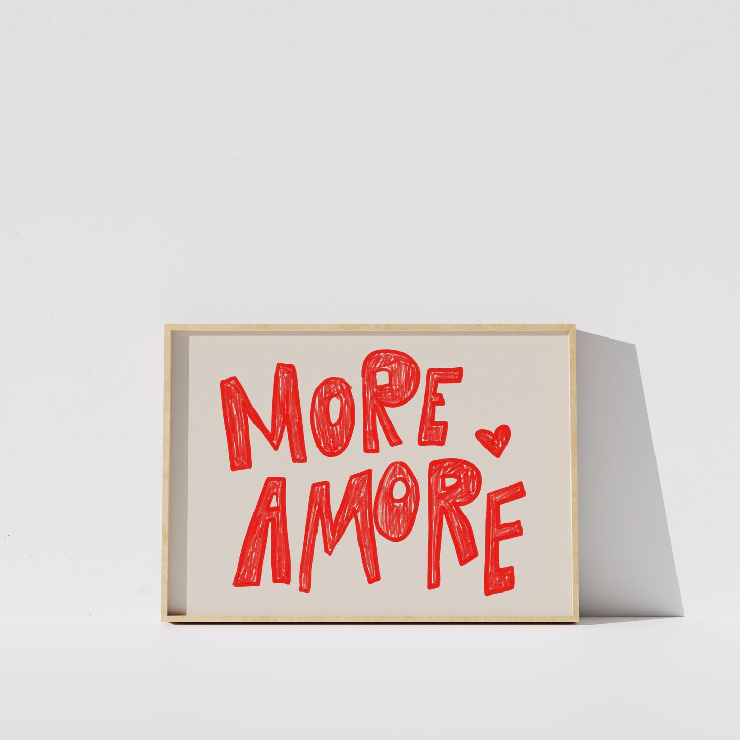 a framed poster with the text "MORE AMORE" written in a playful, handwritten style.