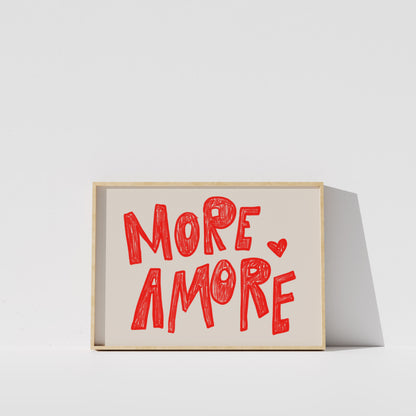 a framed poster with the text "MORE AMORE" written in a playful, handwritten style.