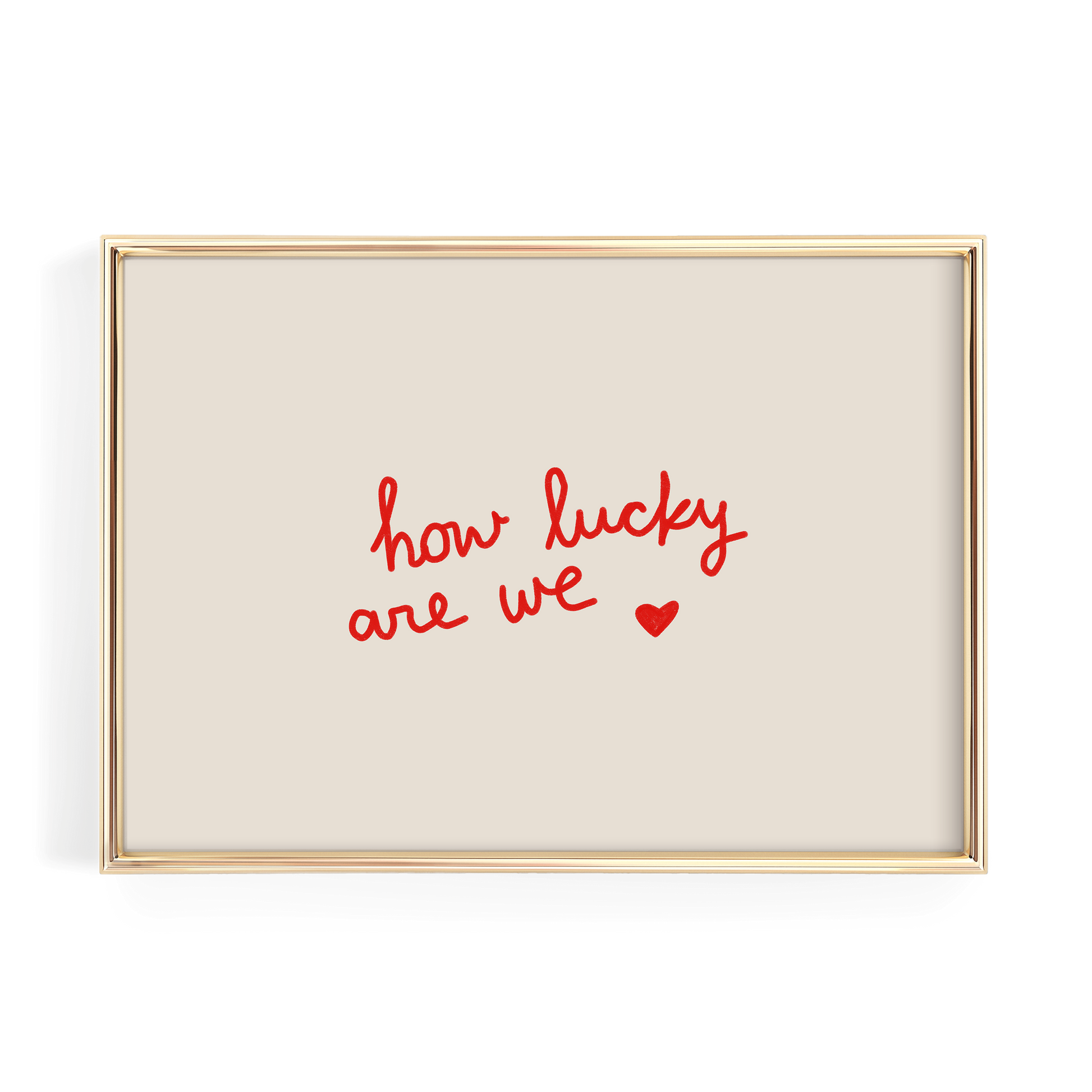 A gold-framed picture with a beige background and the text "how lucky are we" written in red cursive.
